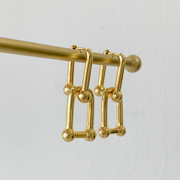 Arracada con dije huesito dorado