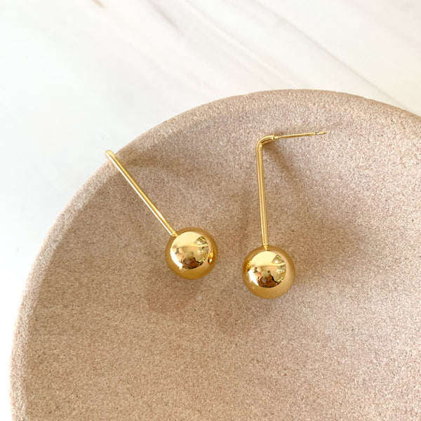Aretes palito con bolita colgando